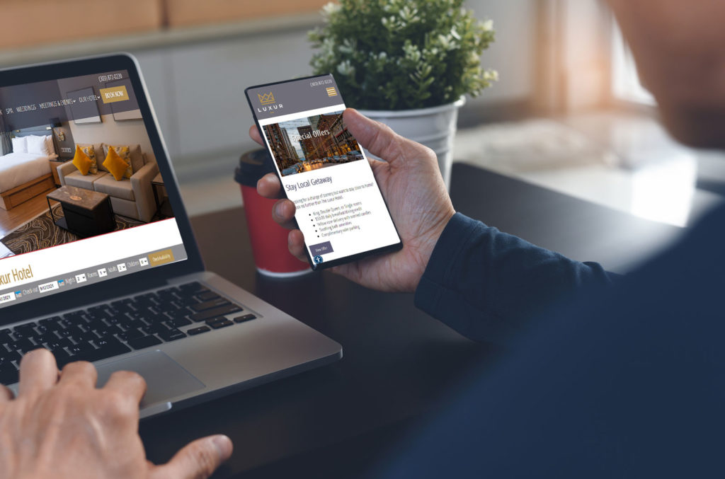 rezStream-TCMS-Website Person on phone and computer looking at a hotel website.