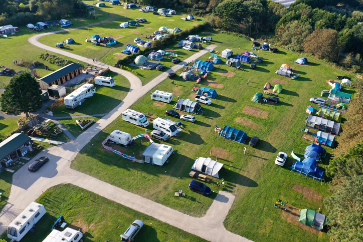 aerial view of a busy campsite with tents caravans and motorhomes, taken in Cornwall, England