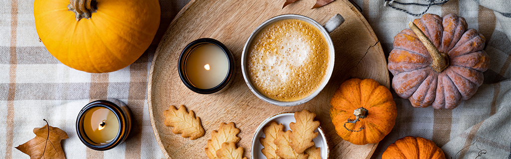 Cozy hotel lobby decorated for Thanksgiving with pumpkins, rustic wreaths, and warm lighting.